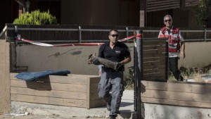 An Israeli police sapper carries part of a rocket which landed in a yard of a house in the city of Sderot, southern Israel, Sunday. (AP/Tsafrir Abayov)